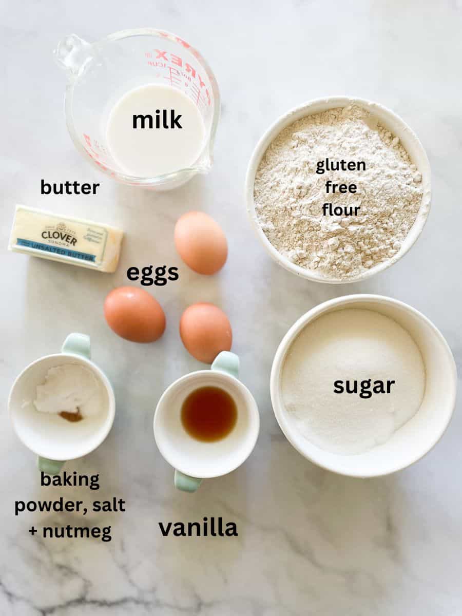 Ingredients for gluten free busy day cake are shown labelled and portioned out: butter, oat flour, baking soda, salt, eggs, vanilla, sugar.