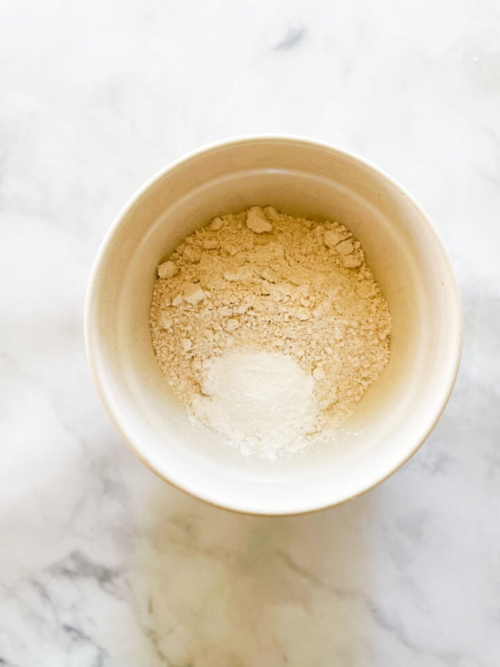 Flour, baking powder, and salt, are combined in a bowl.