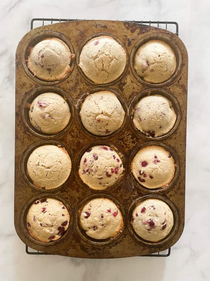 One dozen oatmeal raspberry muffins cool in the tin.