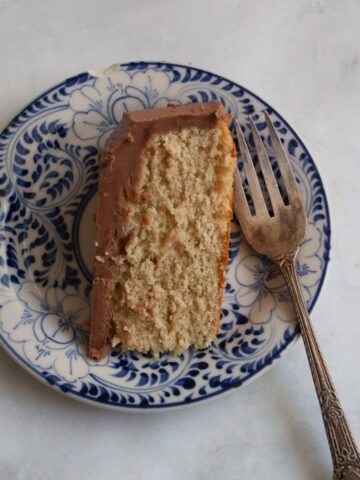 A fork rests to the right of a slice of butter cake on a plate.