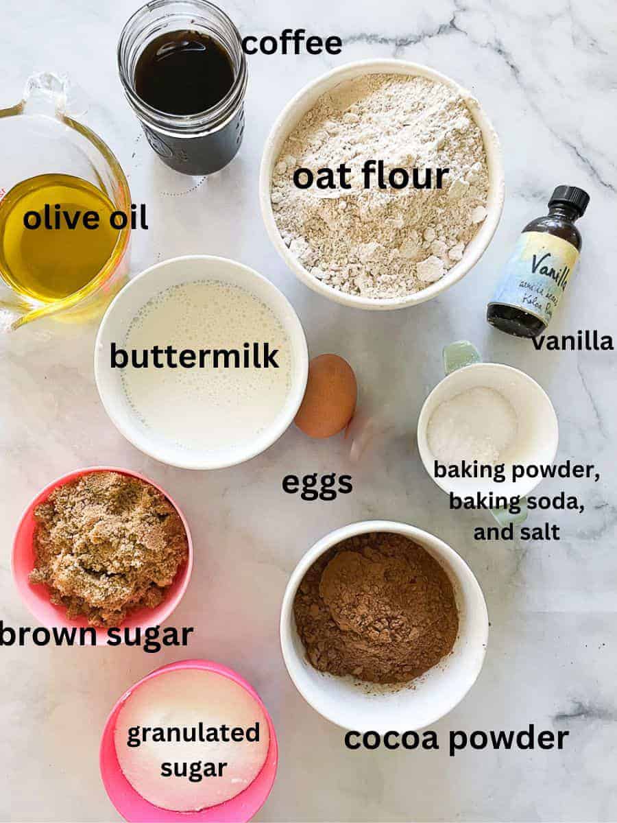 The ingredients for oat flour chocolate cupcakes are shown portioned out and labeled.