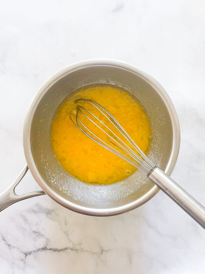 A whisk combines the lemon curd ingredients.