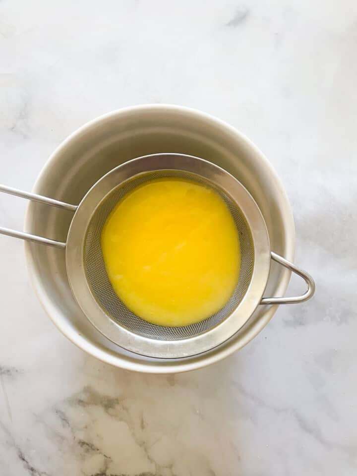 The cooked lemon curd is placed through a sieve.
