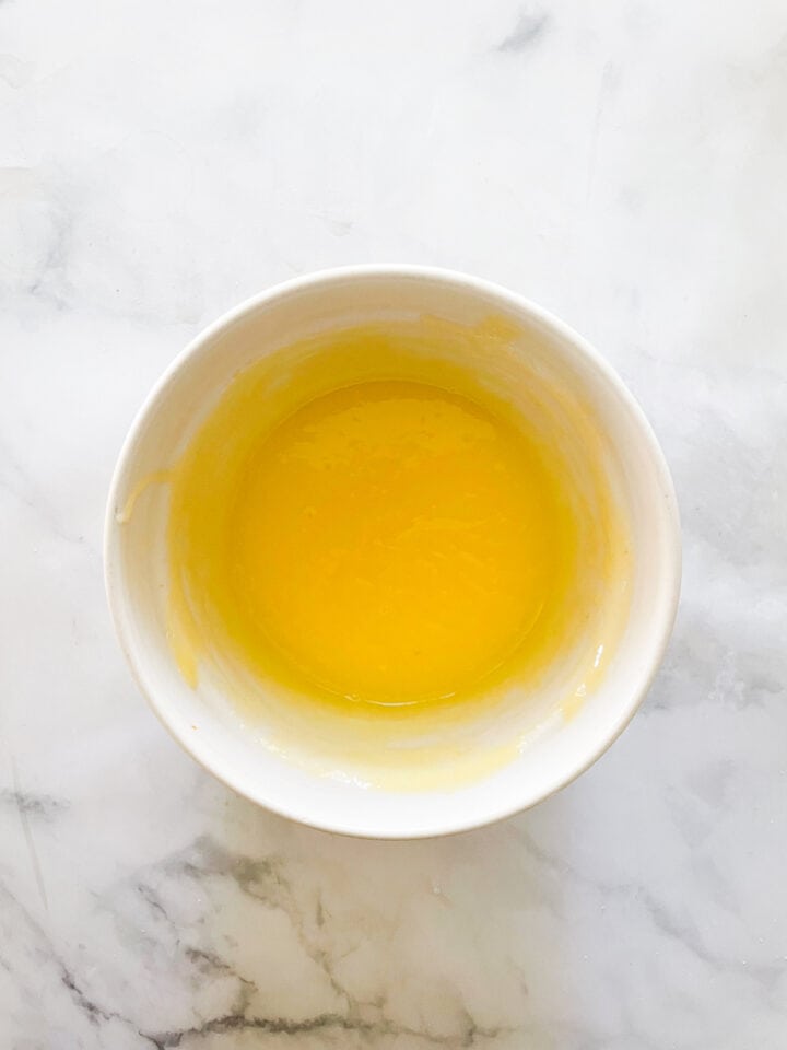 The lemon curd cools in a bowl.