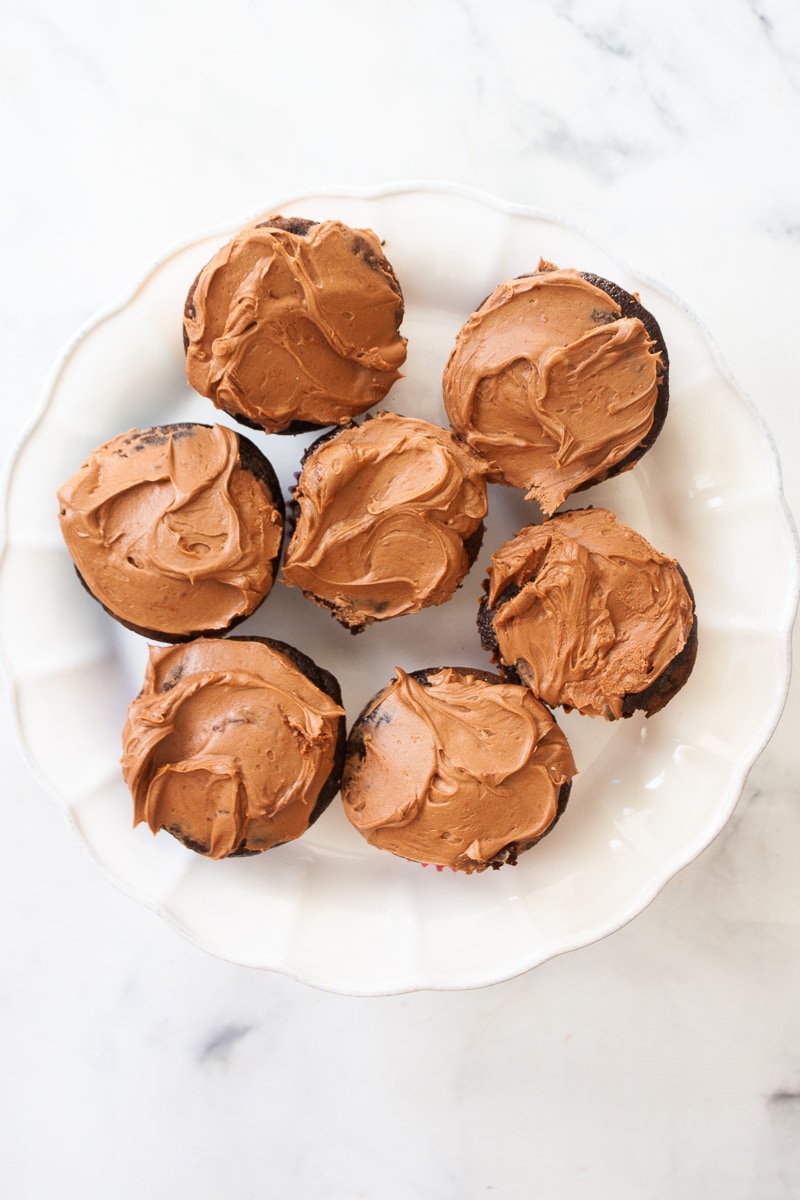 Seven oat flour chocolate cupcakes are served on a cake stand.