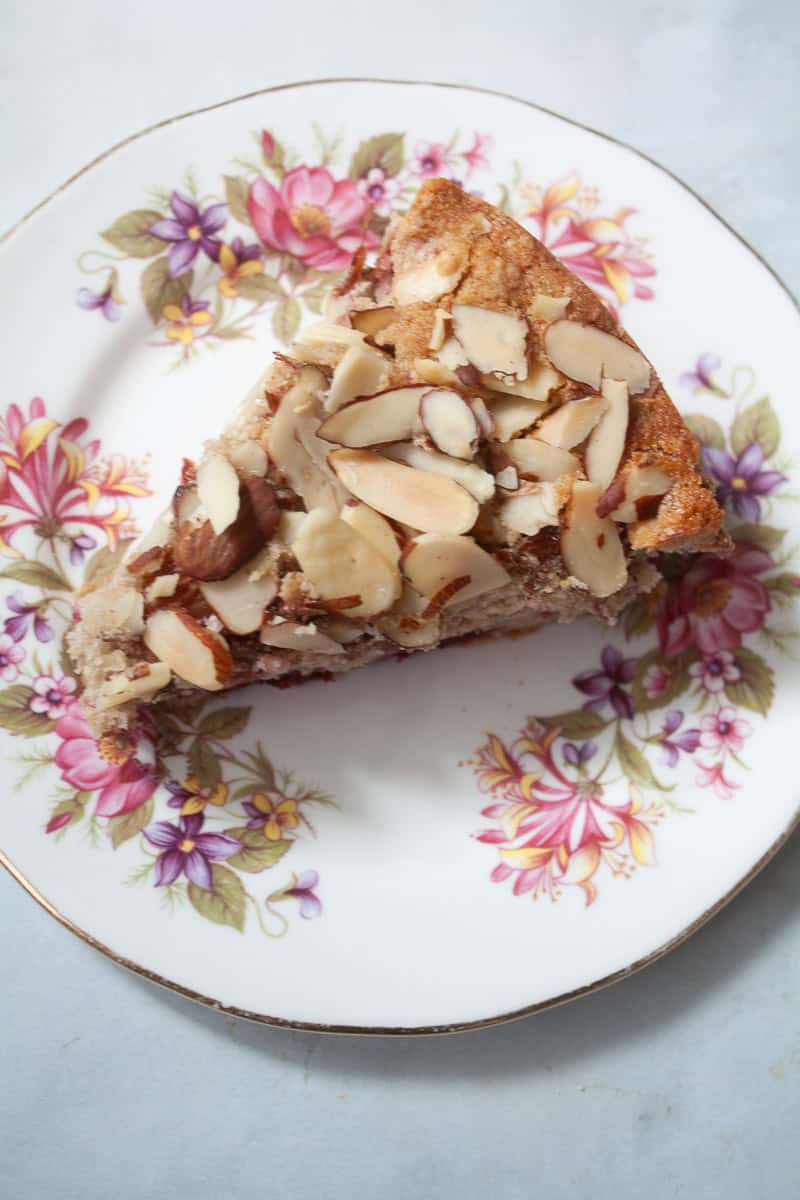 A pretty plate with a slice of raspberry almond cake.