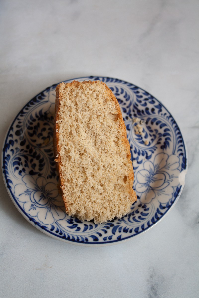A thick piece of oat flour vanilla cake shows its fluffy crumb.