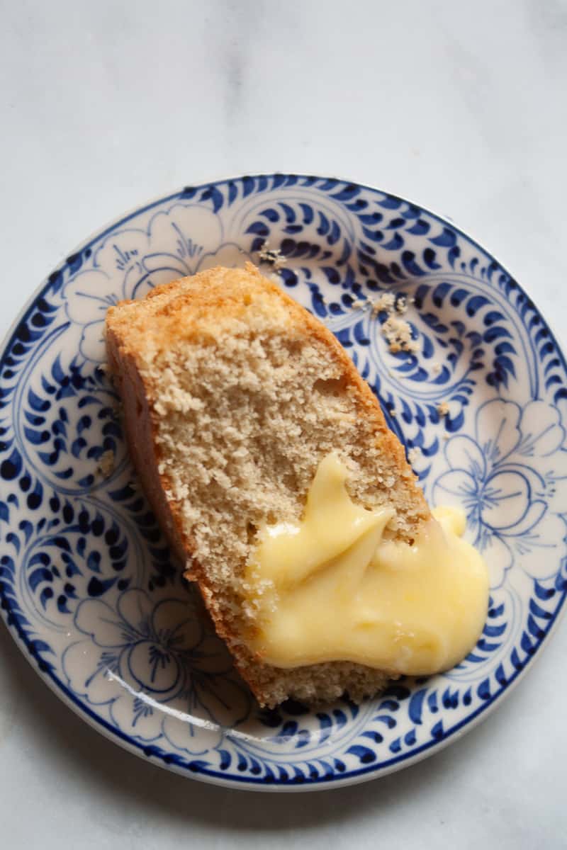 A piece of cake topped with lemon curd.