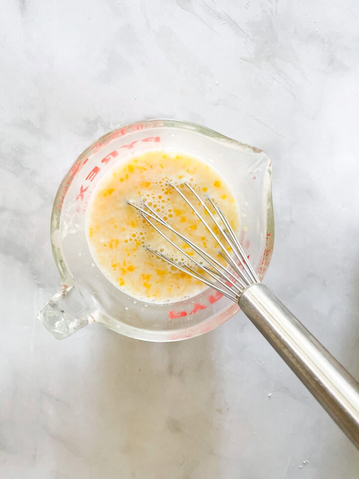 The egg, milk, and butter are whisked together in the measuring cup.