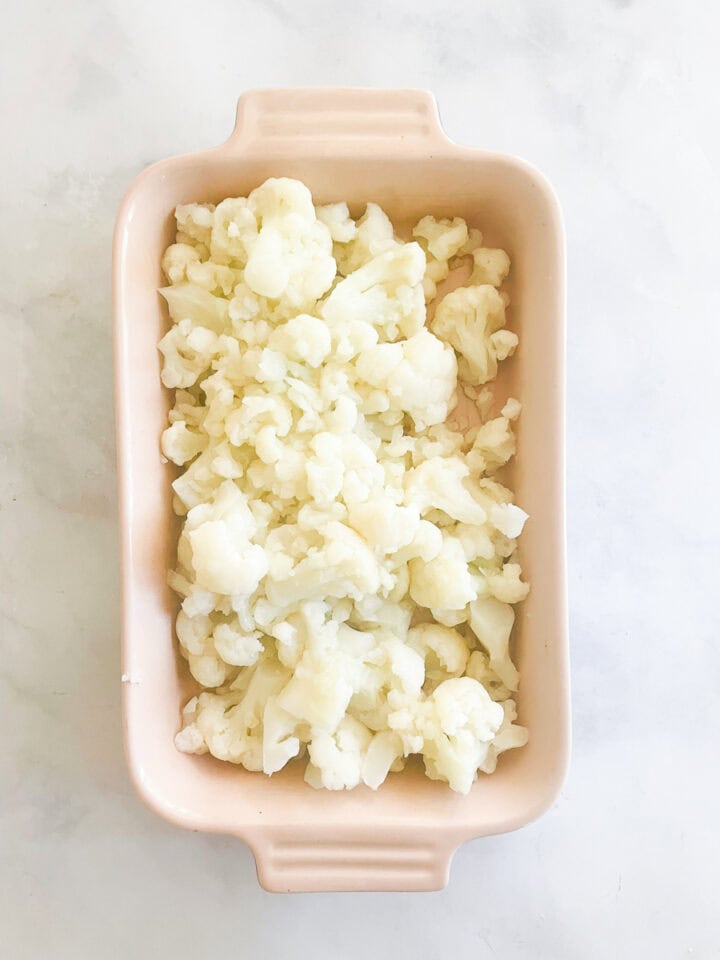 Cauliflower is placed in the baking dish.