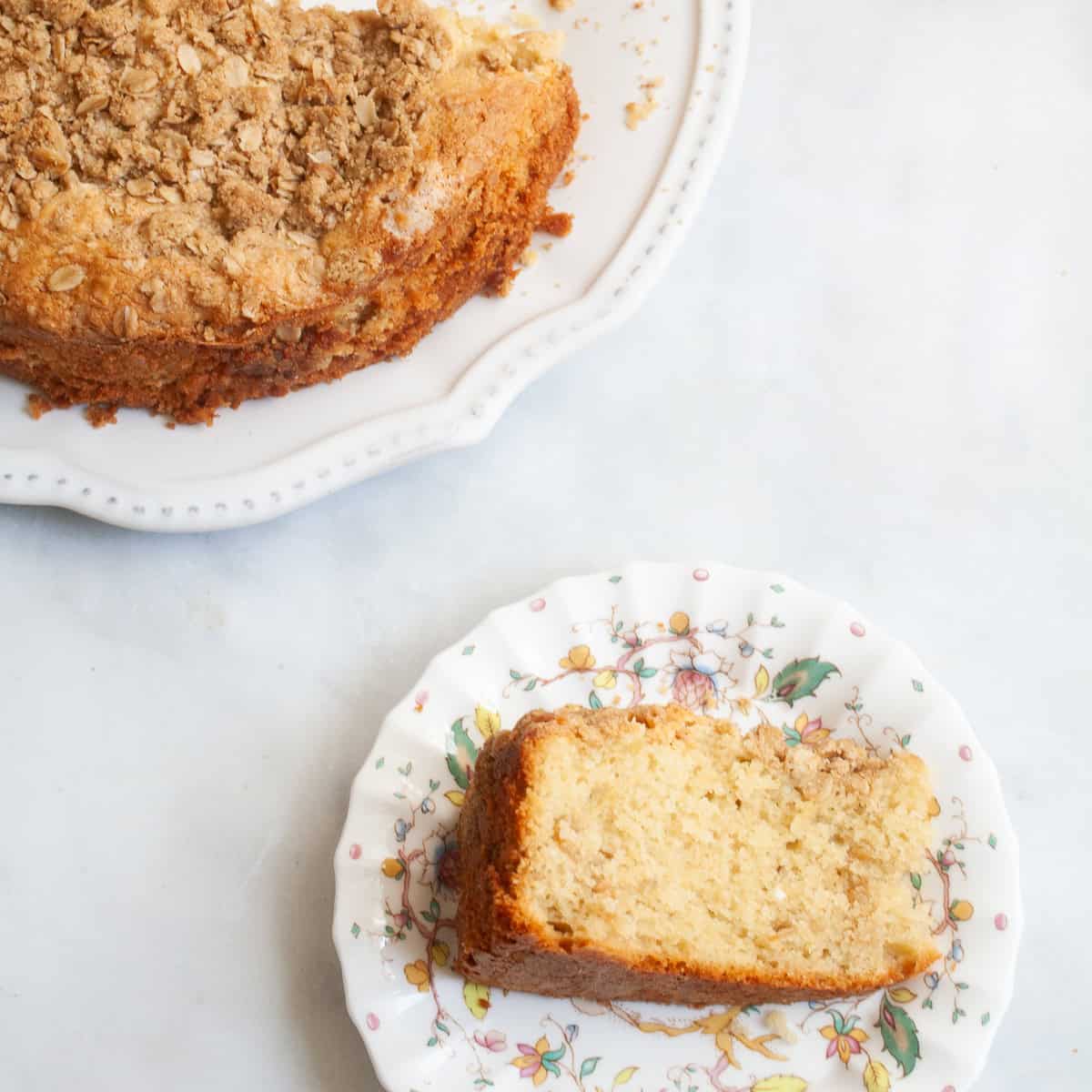 A slice of gluten free lemon curd cake on a plate near the cake.