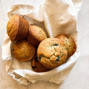 A bunch oat flour blueberry muffins on a white napkin.