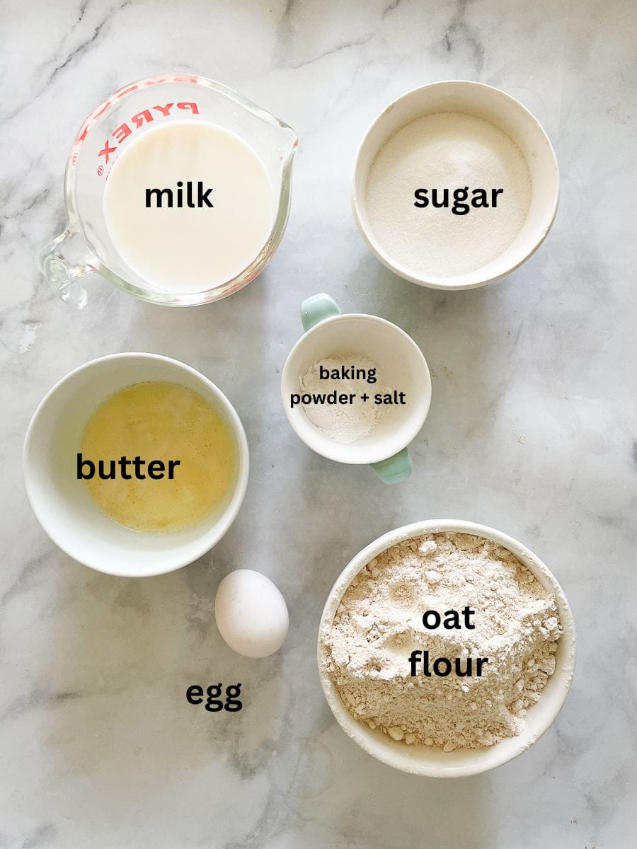 Ingredients needed for oat flour muffins are shown portioned and labelled: oat flour, egg, butter, baking powder, salt, milk, sugar.