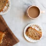 A cup of coffee, two slices of rhubarb bread, and the loaf on a cutting board.