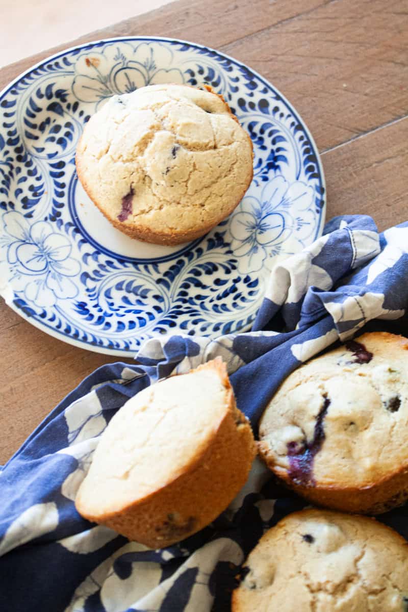 Gluten free banana blueberry muffins next to a muffin on a plate.