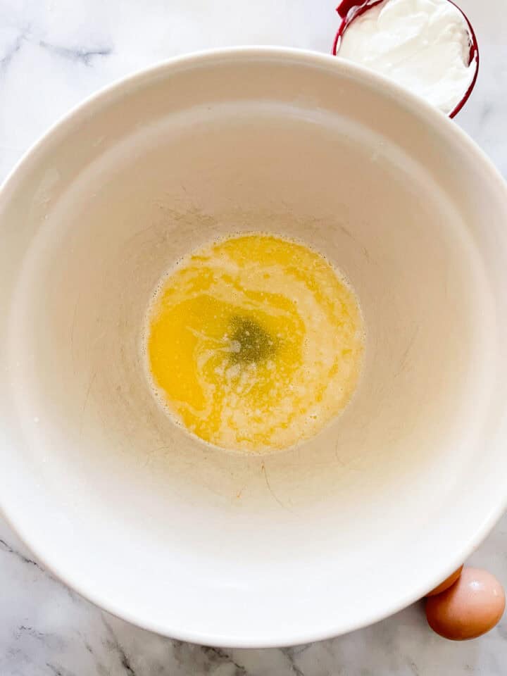 Melted butter and eggs are combined in a bowl.