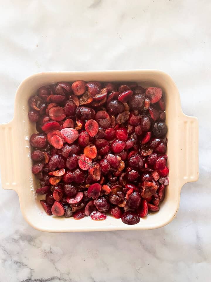 The cherry filling is spread out in a baking pan.