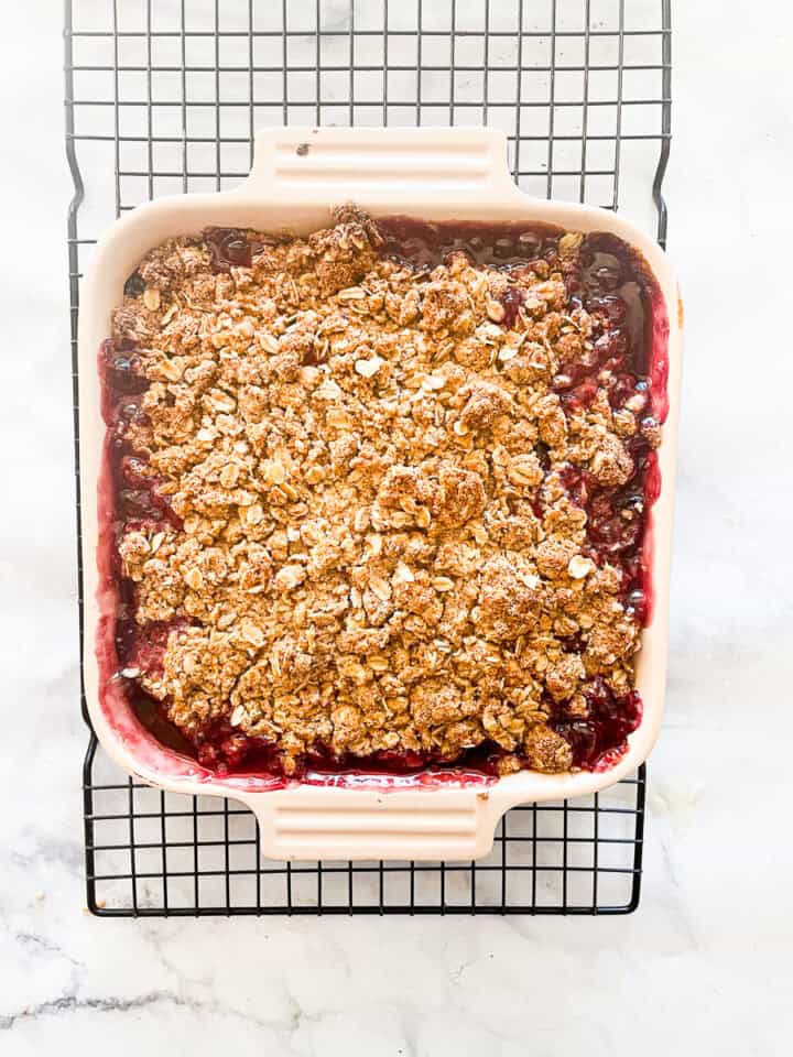 The baked cherry crisp cools on a rack.