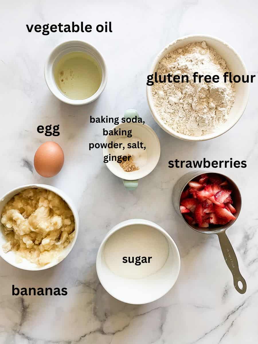 The ingredients for gluten free strawberry banana muffins are shown labeled and portioned.