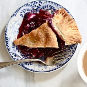 A slice of blueberry blackberry pie on a plate with a fork.