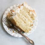 A big piece of gluten free coconut pineapple cake on a flowered plate with a fork.