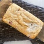 A mini loaf of strawberry rhubarb bread on a blue towel.