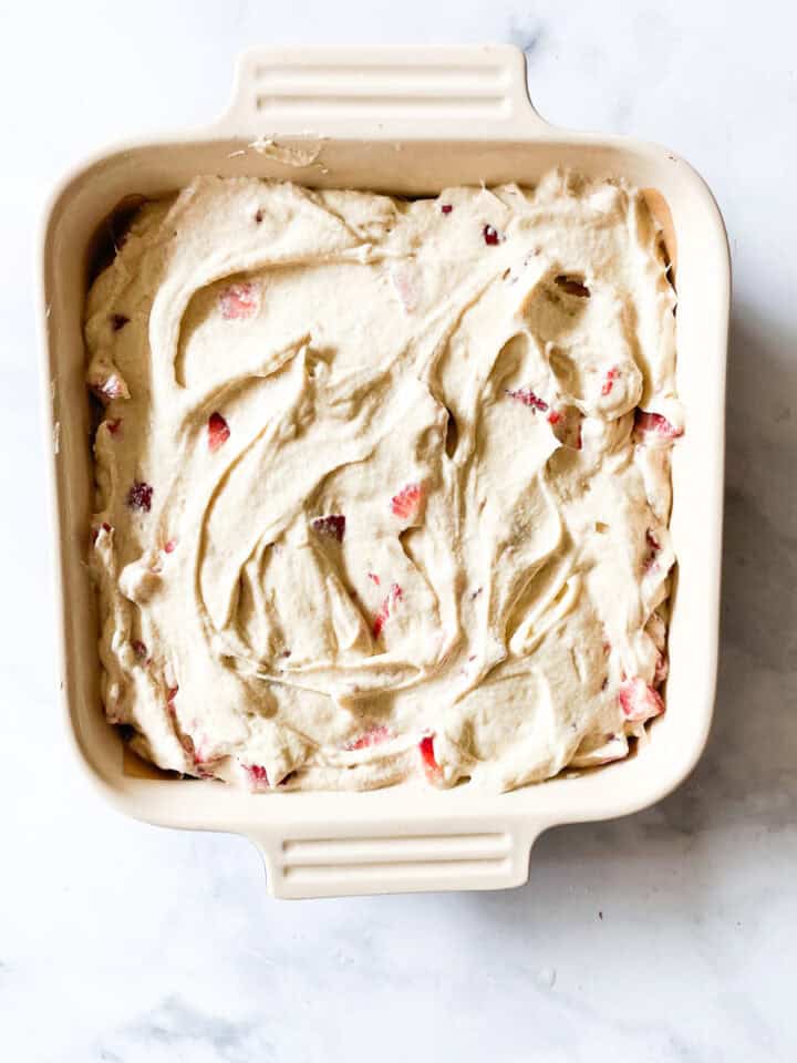 Gluten free strawberry buttermilk cake batter is placed in a pan.