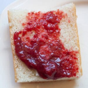 Strawberry honey jam spread on a piece of bread.