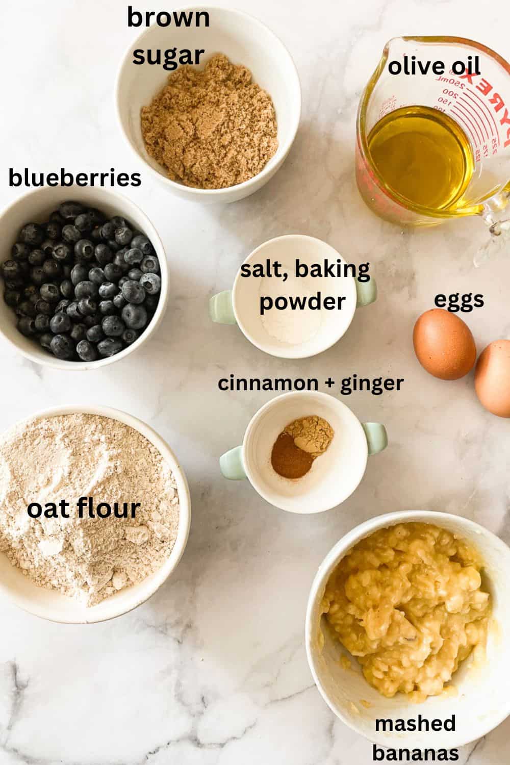 Ingredients for blueberry banana bread are labelled: oat flour, ginger and cinnamon, baking powder and salt, eggs, mashed bananas, blueberries, olive oil.