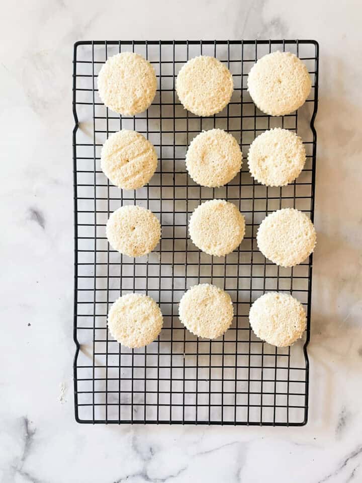 The cupcakes are turned out onto a rack.