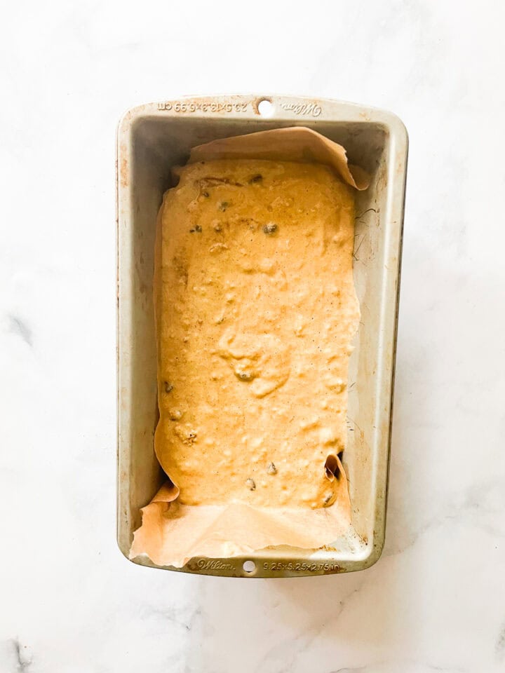 The batter is added to a lined loaf tin.