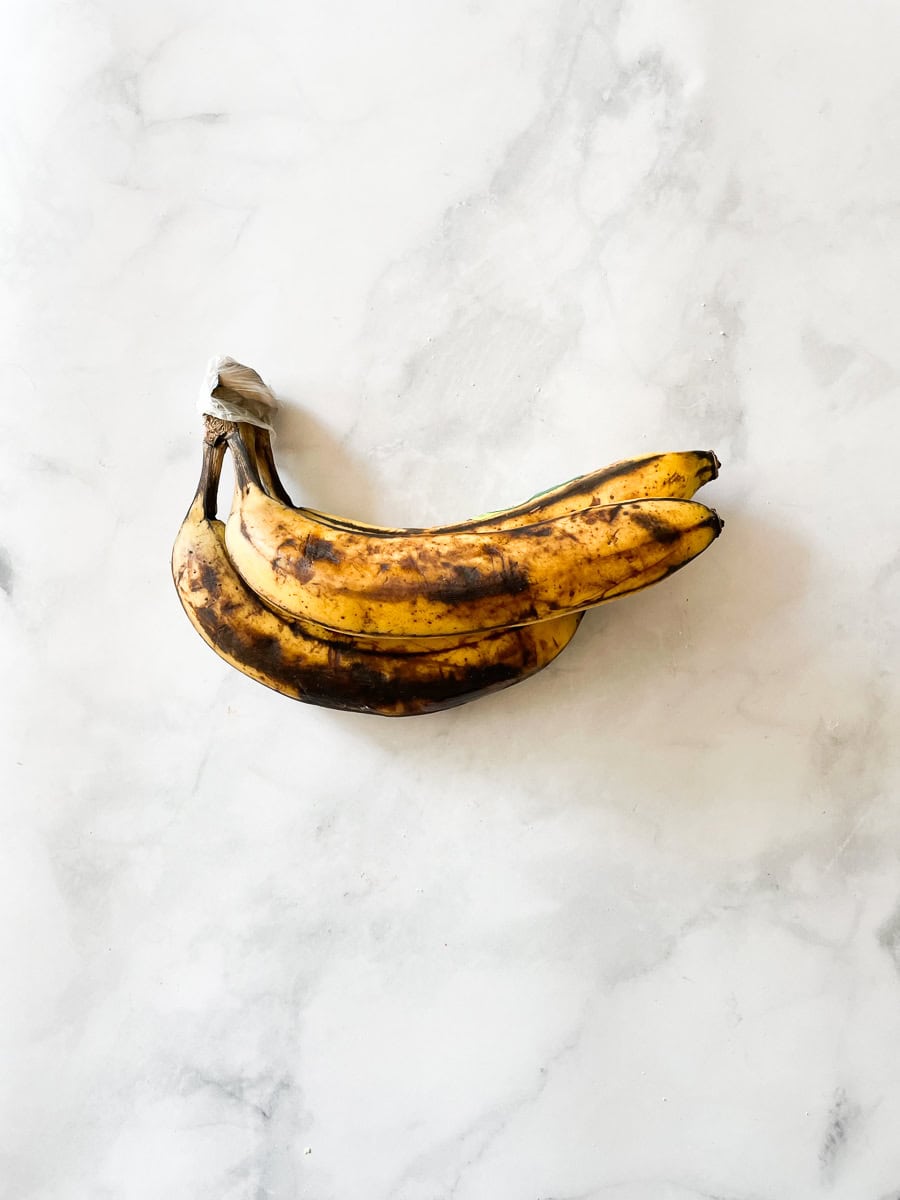 Ripe bananas on a white counter.