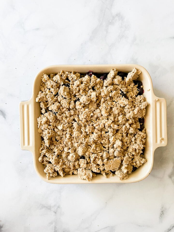 The crisp topping is added to the blueberries.