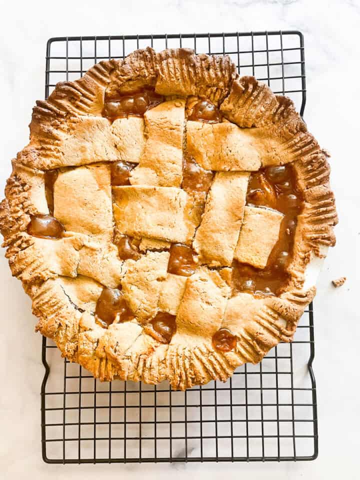 The gluten free peach pie cools on a rack.