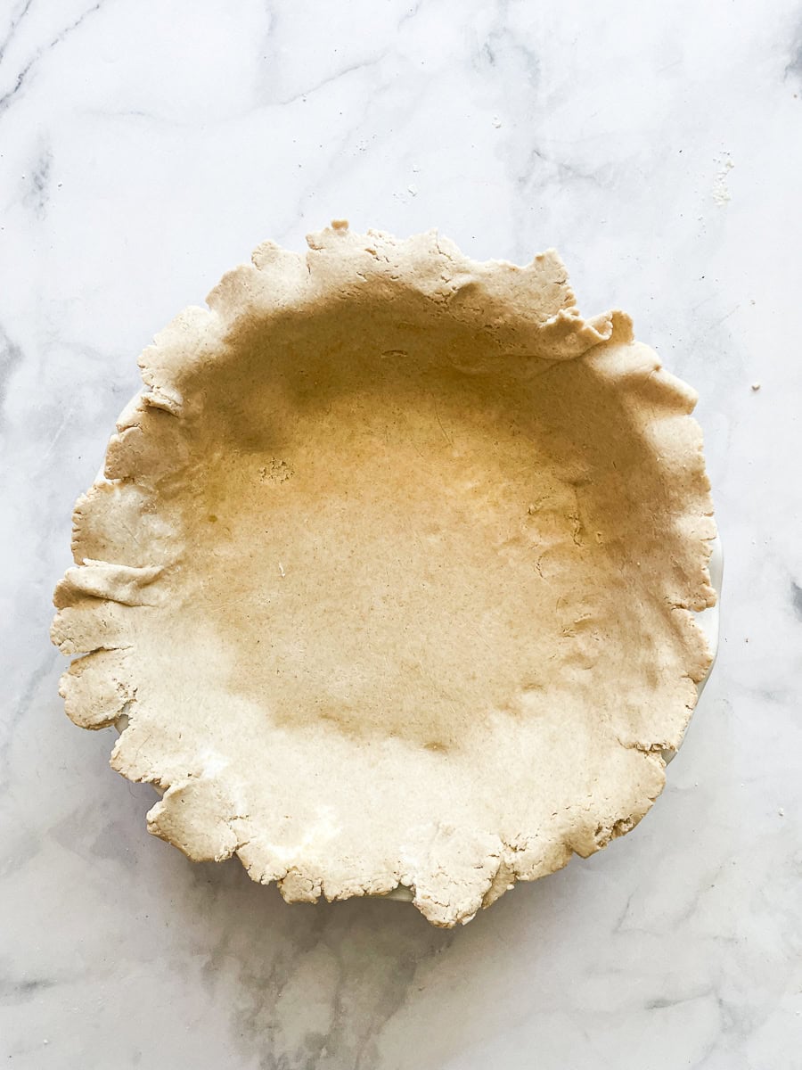 Oat flour pie crust in a pie pan.