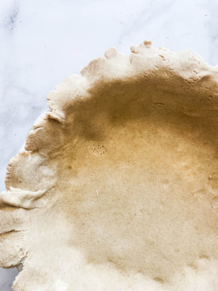 A side view of the pie dough in the pan.