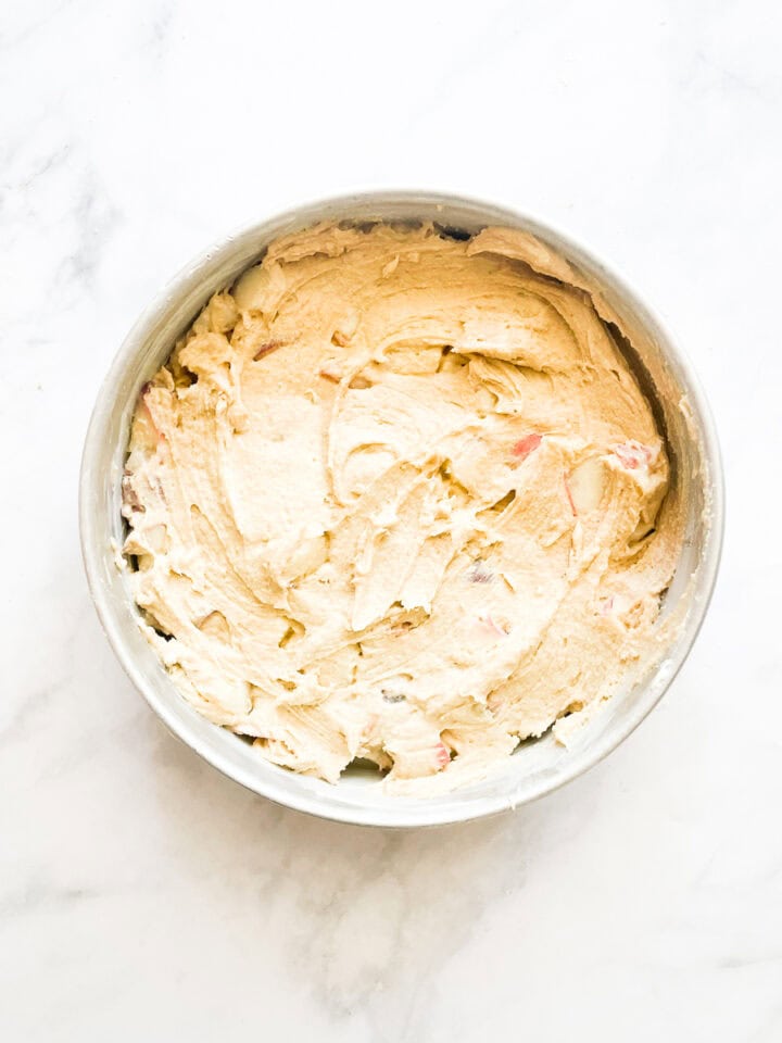 Peach cake batter is added to the prepared pan.