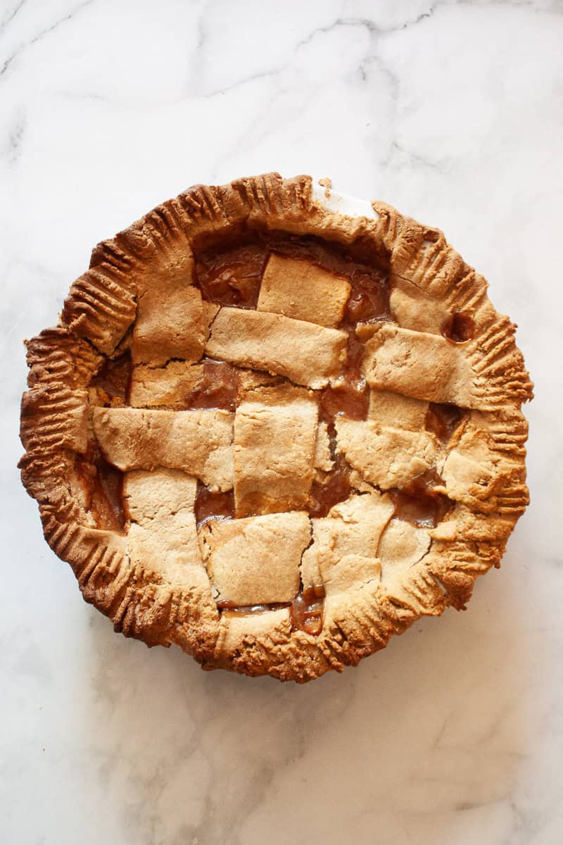 A gluten free peach pie on a white background.