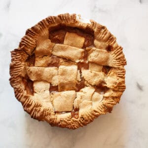 A gluten free peach pie on a white background.