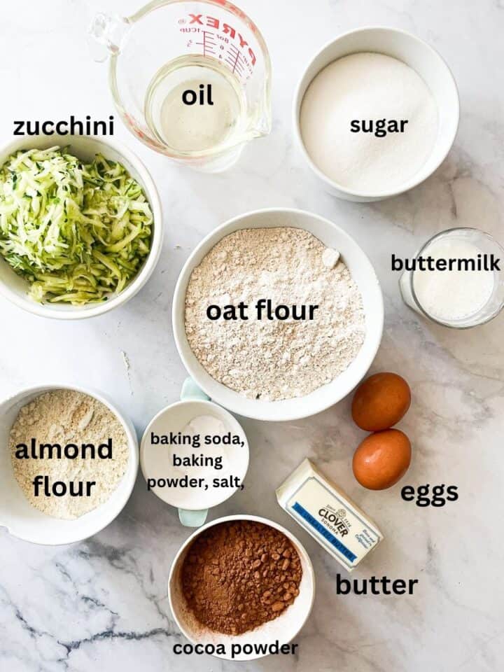 Ingredients for gluten zucchini chocolate are labelled: shredded zucchini, oat flour, almond flour, baking powder, baking soda, salt, sugar, cocoa powder, eggs, butter, oil, buttermilk.