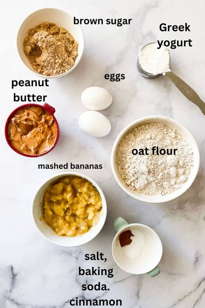 Ingredients for banana peanut butter cake are labeled - oat flour, baking soda, cinnamon, salt, eggs, peanut butter, Greek yogurt, brown sugar.