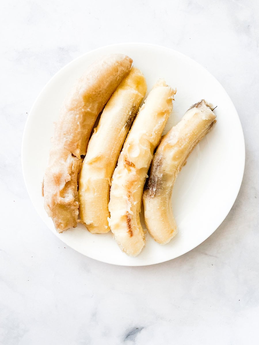 A plate of four frozen bananas.