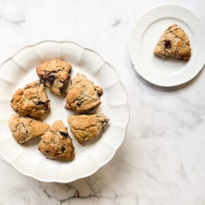 A platter of gluten free cherry scones and one scone on a plate.