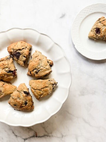 A platter of gluten free cherry scones and one scone on a plate.