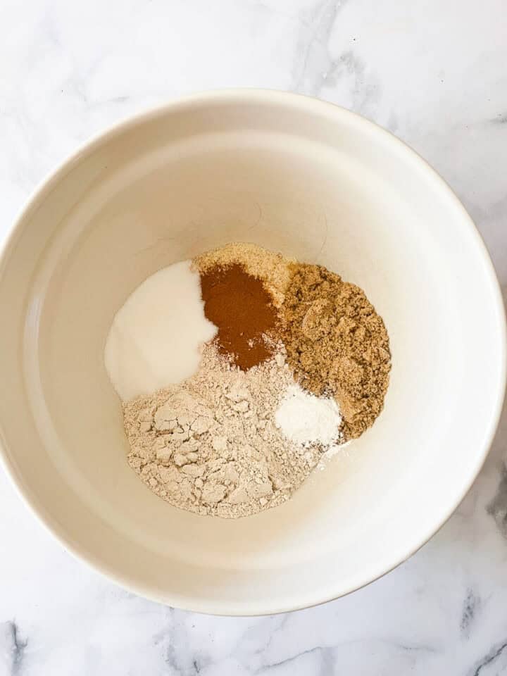 The dry ingredients for zucchini bread are added to a bowl.