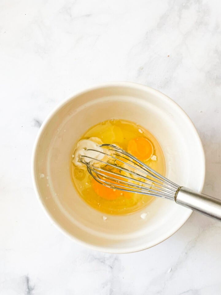 Eggs and oil are whisked in a bowl.