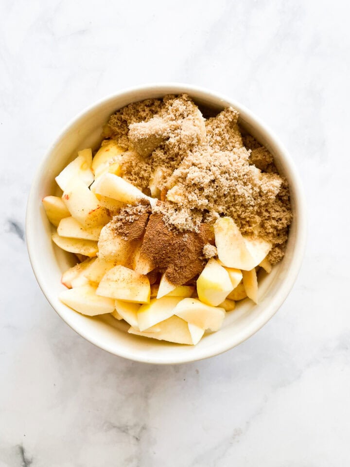 Apple pie filling is added to a bowl.