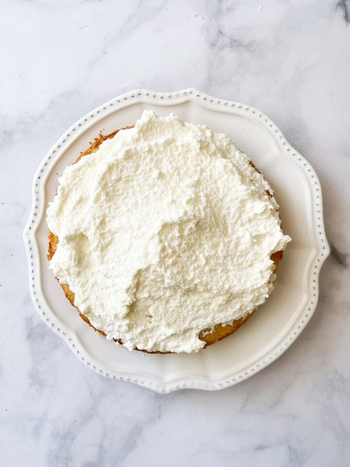 Whipped cream tops the cake.