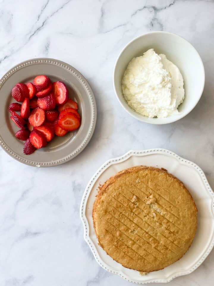 Strawberries and whipped cream wait to be added to the shortcake.