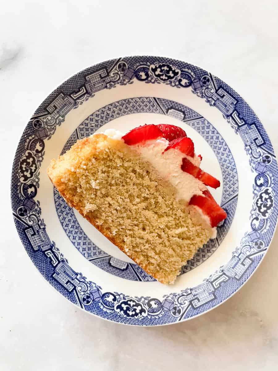 A piece of gluten free strawberry shortcake cake on its side.